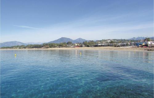 a body of water with a beach and mountains in the background at Gorgeous Apartment In Ajaccio With Wifi in Ajaccio