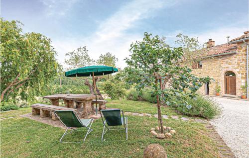 a table and two chairs and an umbrella in a yard at Ginestre 2 in Mengara