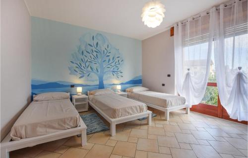 a bedroom with two beds and a tree mural at Casa Del Gallo in Gozzano
