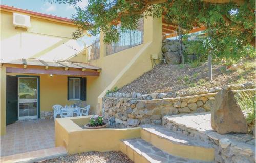 a house with a stone wall and a patio at Nice Apartment In Gonnesa With Wifi in Gonnesa