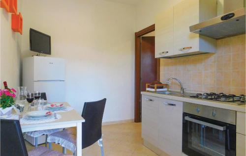 a small kitchen with a table and a stove and refrigerator at Nice Apartment In Gonnesa With Wifi in Gonnesa