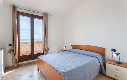 a bedroom with a bed and a large window at Villa 6 in Villaputzu