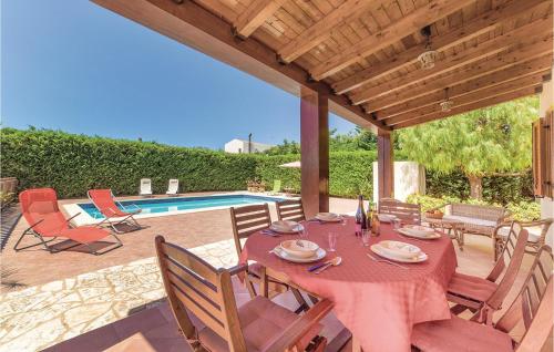 einen Esstisch und Stühle auf einer Terrasse mit einem Pool in der Unterkunft Villa Anna in Menfi