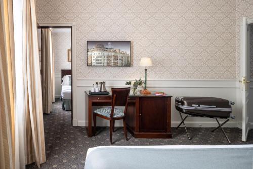 a room with a bed, chair, desk and a lamp at Emperador in Madrid
