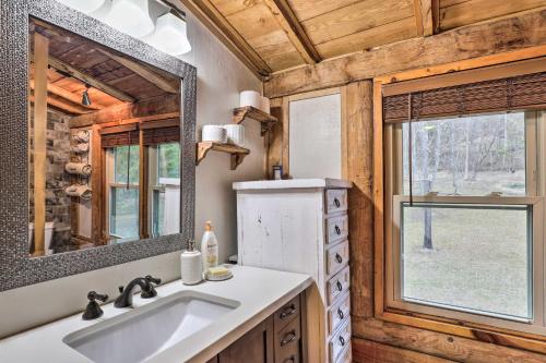 y baño con lavabo y espejo. en Waynesville Cabin with Grill, Fire Pit, and Hot Tub!, en Canton