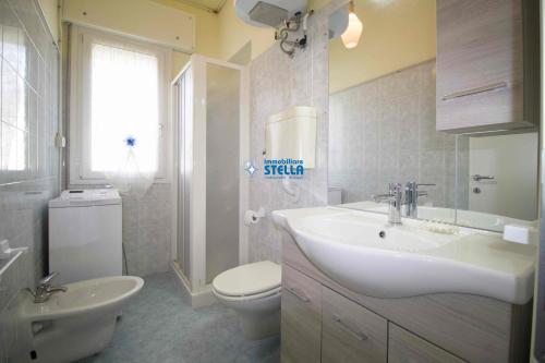 a bathroom with a white sink and a toilet at Condominio Eden in Lido di Jesolo