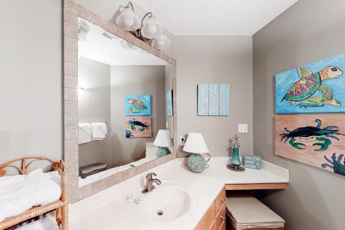 a bathroom with a sink and a mirror at The Dugout by Meyer Vacation Rentals in Gulf Shores