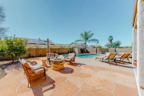 a patio with chairs and a table and a pool at Bedrock Lane in Oro Valley
