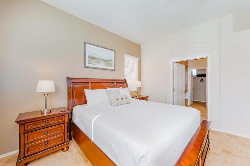 a bedroom with a white bed and a night stand with a lamp at Bedrock Lane in Oro Valley