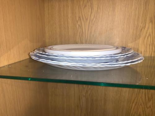 a stack of plates sitting on top of a shelf at K76 - Very Nice 2-bedrooms Apartment -2 big beds-1 single bed in Tartu