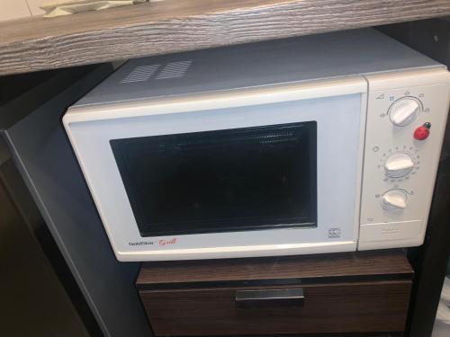 a white microwave sitting on top of a wooden table at K76 - Very Nice 2-bedrooms Apartment -2 big beds-1 single bed in Tartu