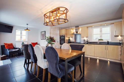 a kitchen and dining room with a wooden table and chairs at Larchfield Grange, Luxury House with Stunning Views in Abergavenny