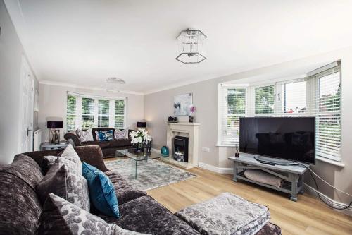 uma sala de estar com um sofá e uma televisão de ecrã plano em Beautiful 4-bed home, Hot Tub & Stunning Views! em Abergavenny
