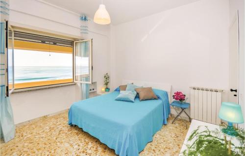 una camera con un letto blu e una grande finestra di Silene a Torvaianica