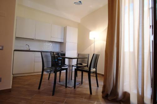 a dining room table with black chairs in a room at Nuraghe Apartments in Teulada
