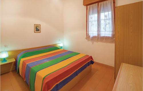 リド・デッレ・ナツィオーニにあるGinestra Int,9-cの窓付きの客室のカラフルなベッド1台分です。