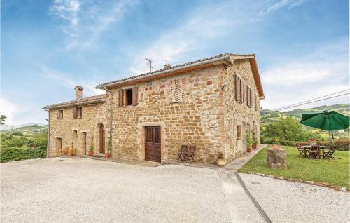 an old stone house with a table and an umbrella at Ginestre 3 in Mengara