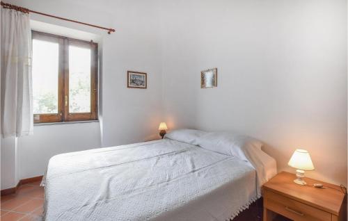 a white bedroom with a bed and a window at Nice Home In Raccuja With Kitchen in Raccuia