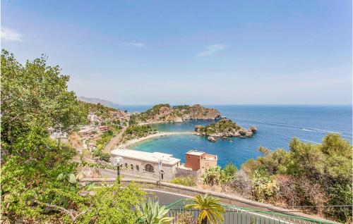 a building on a hill next to a body of water at Nice Home In Raccuja With Kitchen in Raccuia