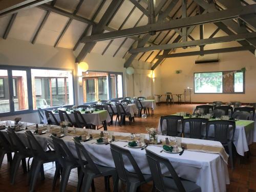 une salle remplie de tables et de chaises avec des nappes blanches dans l'établissement Domaine Du Bois du Loup, à Saint-Agnan