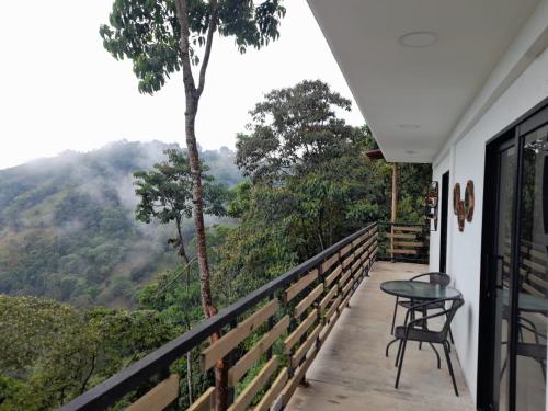 a balcony with a table and a view of the mountains at Entre Verdes Hotel & Glamping in Medellín
