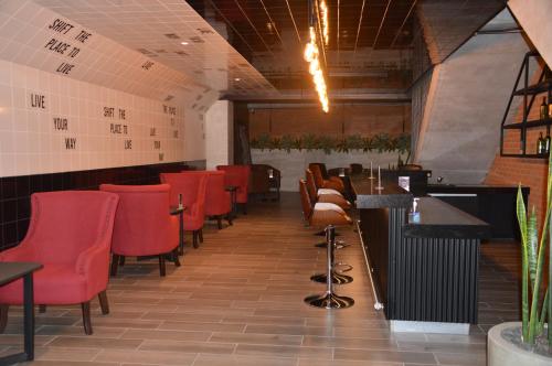 a dining room with red chairs and a bar at Cozy Stays Cayala Apartments 5 in Guatemala