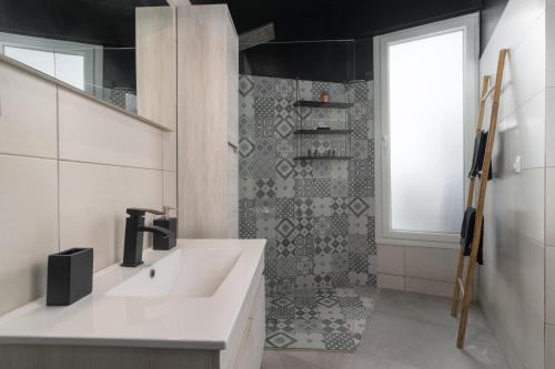 a bathroom with a white sink and a shower at Milos Guesthouse in Triovasálos