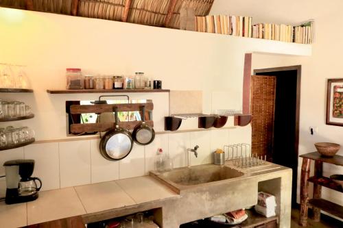 a kitchen with a sink and pots and pans on the wall at Vibra Guesthouse Popoyo in Popoyo