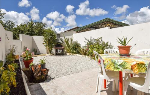 a patio with a table and chairs and plants at Stunning Home In St Avaugourd Des Lande in Saint-Avaugourd-des-Landes