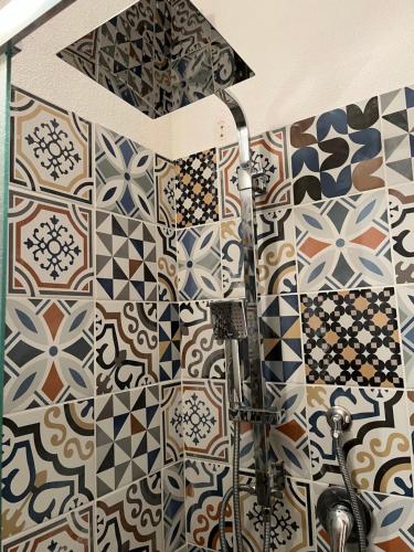 オルビアにあるIknos Guest Houseのタイル張りの壁のバスルーム(シャワー付)