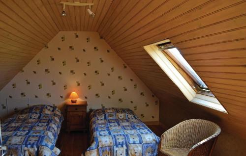PlozévetにあるAmazing Home In Plozevet With 3 Bedroomsの屋根裏部屋 ベッド2台、窓2つ付