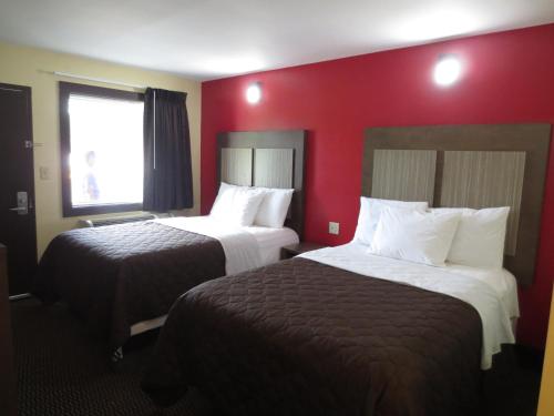 Habitación de hotel con 2 camas y pared roja en Brick Motor Inn, en Brick