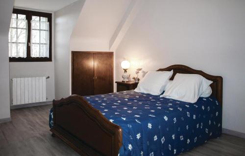 a bedroom with a bed with a blue blanket and white pillows at 4 Bedroom Cozy Home In Yvias in Yvias