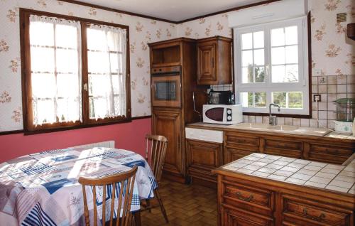 une cuisine avec des placards en bois et une table avec un comptoir dans l'établissement 4 Bedroom Cozy Home In Yvias, à Yvias