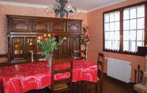a dining room with a table with a vase of flowers at 4 Bedroom Cozy Home In Yvias in Yvias