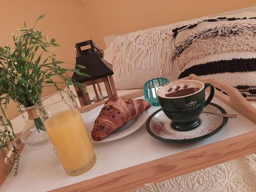 a cup of coffee and a croissant and a glass of orange juice at Restauracja Hotel 4u in Kańczuga