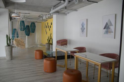 a room with tables and chairs and paintings on the wall at Cozy Stays Cayala Apartments 5 in Guatemala