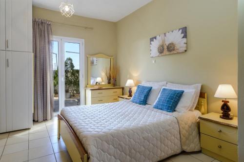 1 dormitorio con 1 cama grande con almohadas azules en Nikos & Vassilis apartments Kefalonia, en Vlachata