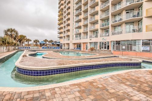 a pool in front of a large apartment building at Balcony and Beach View! Remodeled N Myrtle Beach Gem in Myrtle Beach