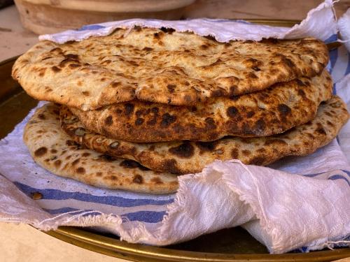 three pita breads on a plate on a table at Kasbah Tamsna in Ouarzazate