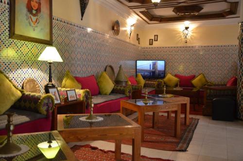 a living room with colorful couches and tables at Hotel Cap Sim in Essaouira
