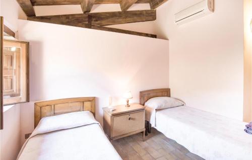 a bedroom with two beds and a table with a lamp at Casale Malena in Casa Oliveto