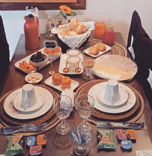 a table with plates of food and wine glasses at Hotel Pousada Laje de Itauna in Saquarema