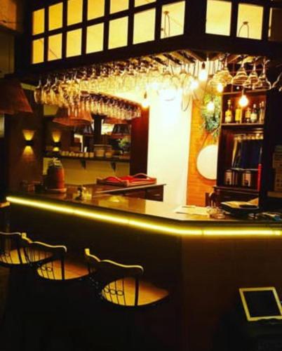 a bar with chairs and a counter with wine glasses at Hotel Pousada Laje de Itauna in Saquarema