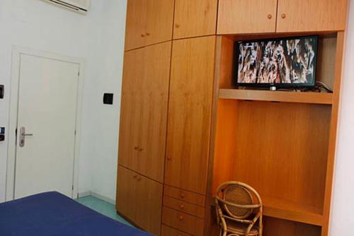 a bedroom with a tv in a wooden cabinet at Hotel Residence La Darsena in Agropoli