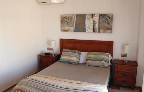 Los DolsesにあるStunning Home In Orihuela Costa With 2 Bedrooms, Wifi And Outdoor Swimming Poolのベッドルーム1室(ベッド1台、ナイトスタンド2台、ランプ2つ付)