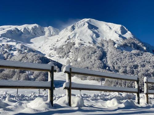 a snow covered mountain with a bench in front of it at Hotel Miletto in San Massimo