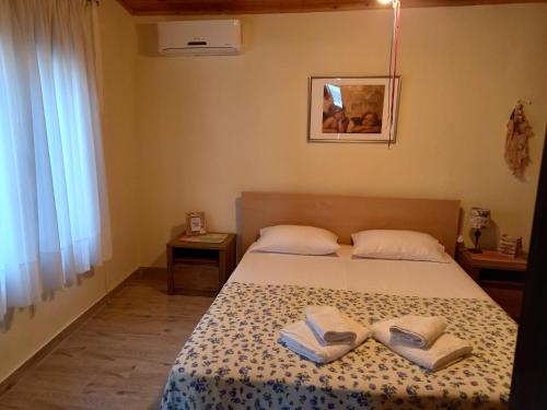 a bedroom with a bed with two towels on it at Glastri Ammouliani in Ammouliani