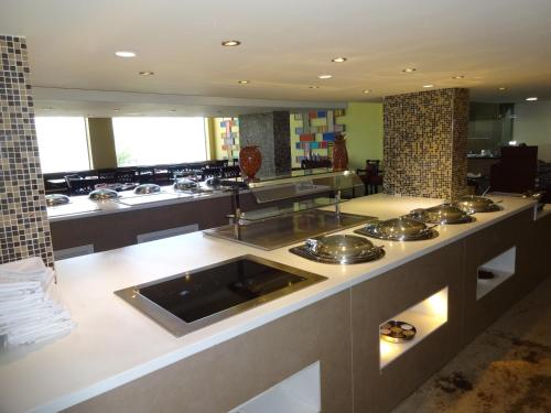 a large kitchen with stainless steel sinks and counters at Regency Madurai by GRT Hotels in Madurai