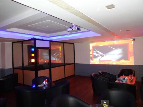 a dining room with black chairs and a projection screen at Regency Madurai by GRT Hotels in Madurai